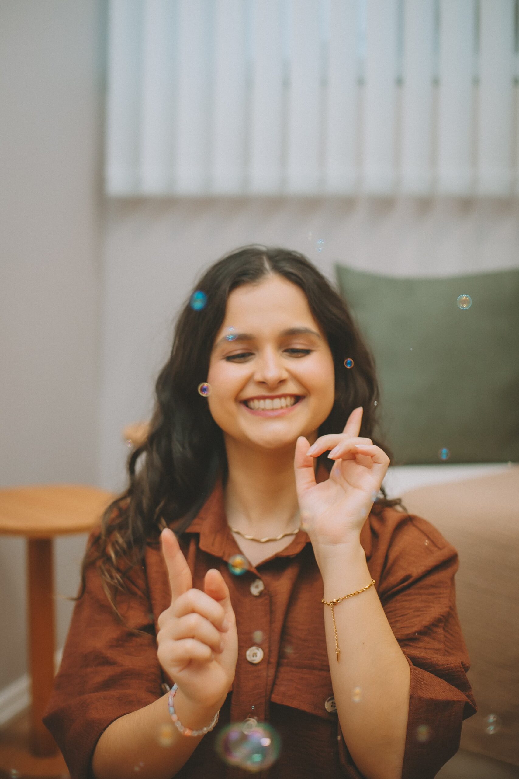 Kananda Telski sorrindo em meio a bolhas de sabão no consultório de psicologia infantil